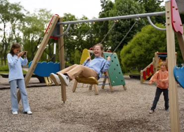 Trois enfants s'amusent sur une aire de jeux en ile de france