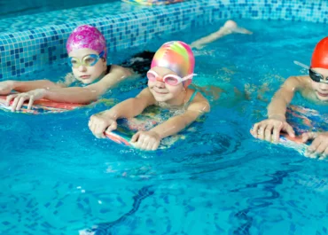 Trois enfants nagent dans une piscine en ile de france